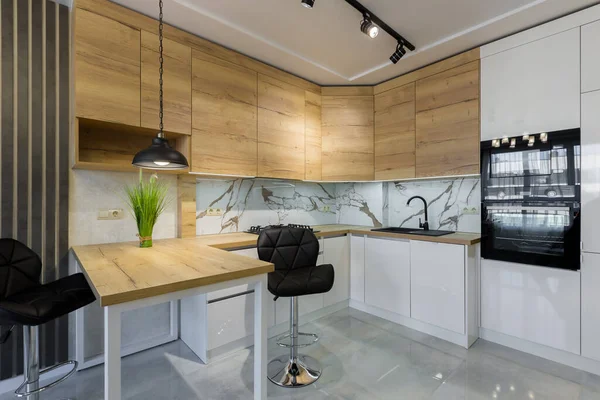一个现代化厨房的内部 在一个小公寓里有一个带有木制插头和白色大理石瓷砖的酒吧 — 图库照片