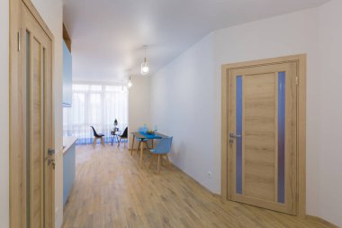 Beyaz duvarları olan büyük bir dairedeki koridorların içi.