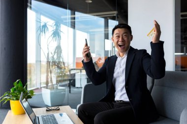 Bankacı kredi limitinde artış kaydetti, Asyalı işadamı elinde telefon ve banka kartıyla sevindi, Erkekler zaferi kutladı