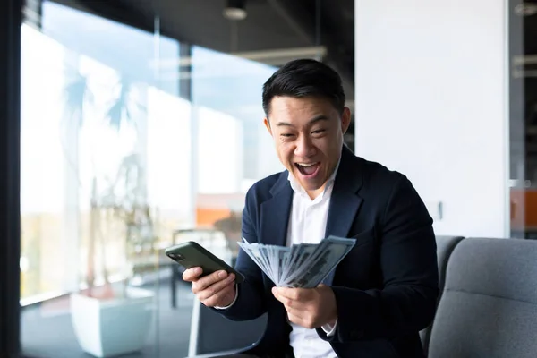 Szczęśliwy Sukces Azjatycki Biznesmen Liczy Fale Rzuca Pieniądze Biurze Patrząc — Zdjęcie stockowe