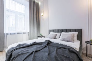 Yatak odasının içi modern, açık gri renklerde.