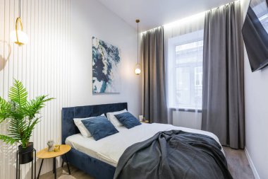 Yatak odasının içi modern, açık gri renklerde.