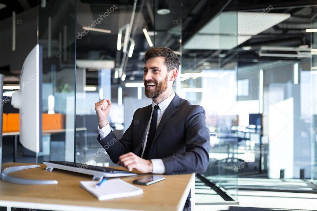 Successful seo man, boss business man, celebrates victory by working on computer in modern office