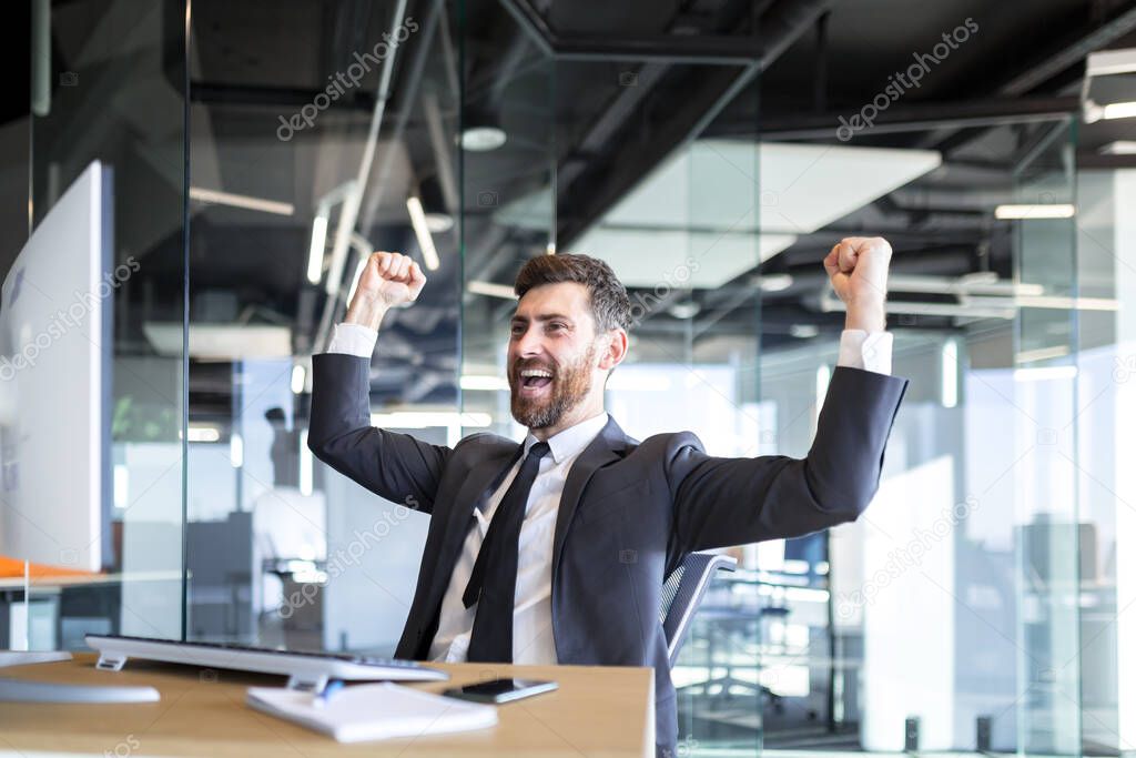 Successful seo man, boss business man, celebrates victory by working on computer in modern office