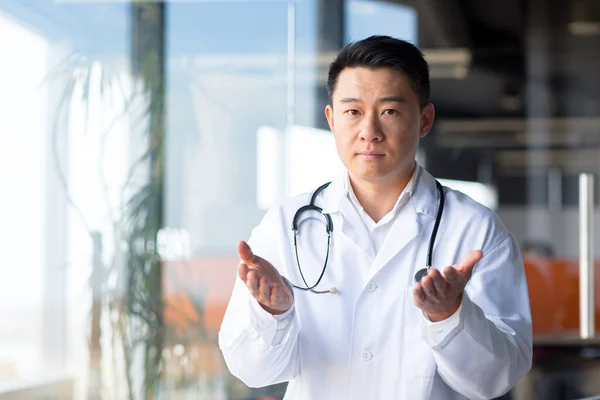严肃的亚洲医生看着网络摄像头 在网上听病人谈话 从诊所远程工作的男人 — 图库照片