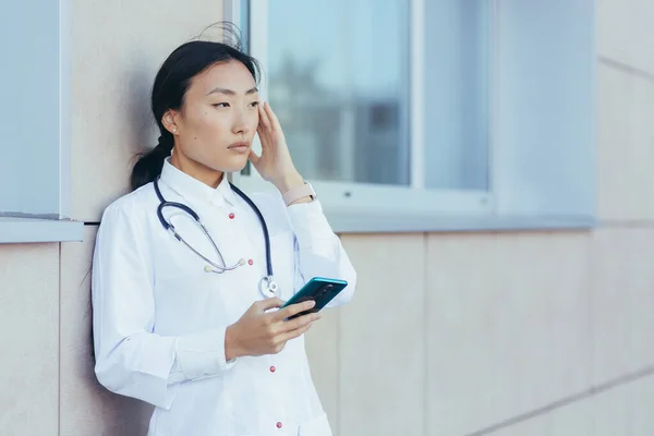 Enfermera Médica Triste Asiática Cerca Clínica Durante Descanso Utiliza Teléfono — Foto de Stock