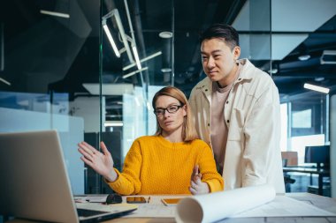 Brainstrom iş ekibi görevleri çözmekten sorumludur, çalışanlar Asyalı erkek ve kadın çalışma arkadaşları modern bir ofiste birlikte çalışırlar, ekran bilgisayarlarına bakarlar, ortak bir bilişim projesi.
