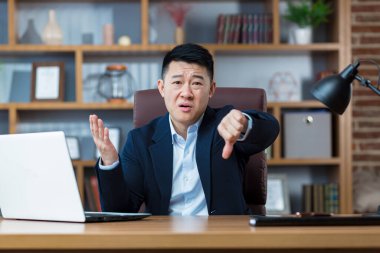 İş adamı çığlık atıyor ve kameraya bakıyor. Parmağını aşağıda tutuyor. Adam sonuçtan hayal kırıklığına uğruyor.