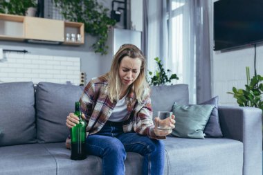 Evde yalnız bir kadın, keder ve depresyon, güçlü alkol, kanepede oturan alkolik.