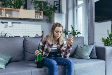 Evde yalnız bir kadın, keder ve depresyon, güçlü alkol, kanepede oturan alkolik.