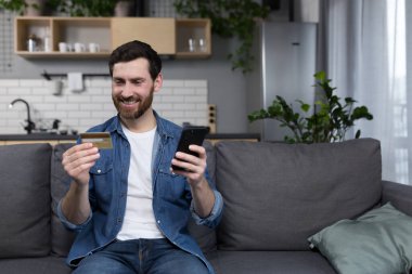 Evde bankacılık işlemleri yapan, cep telefonunda bankacılık başvurusu yapan ve kredi kartı kullanan bir serbest çalışan.