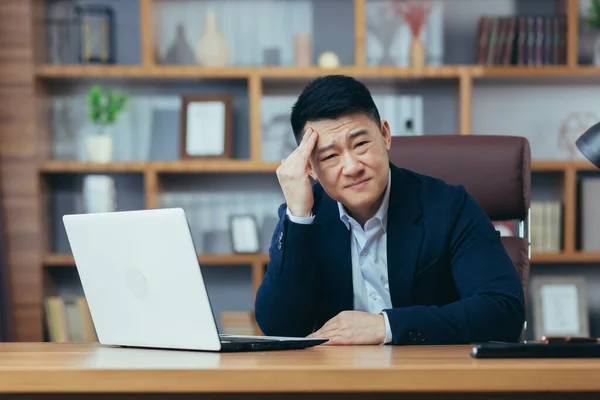 Empresário Perturbado Sentado Trabalho Escritório Asiático Pensativo Trabalhando Laptop — Fotografia de Stock