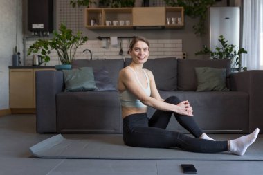 Evde sabah egzersizi yapan, spor yapan bir kadın.