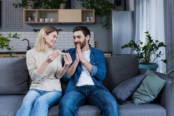 Happy Couple Sitting Sofa Home Man Woman Got Positive Pregnancy — Foto de Stock