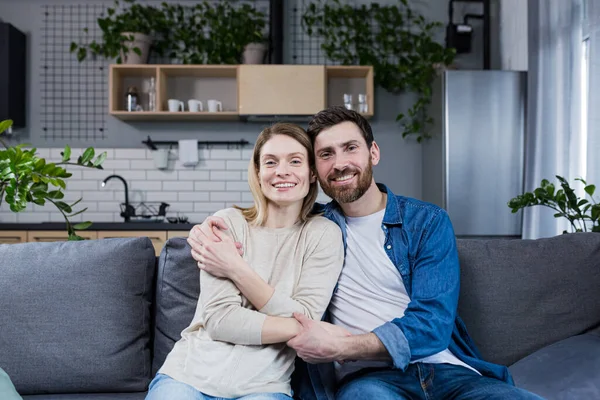 Young Married Couple Man Woman Sitting Together Sofa Hugging Portrait — Foto de Stock