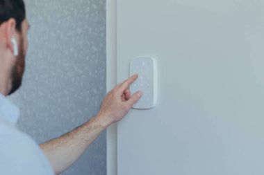 İşadamı parola kodunu alarm panelinde, beyaz duvarda, sakallı adamın dikiz aynasından giriyor.