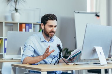 Başarılı ve mutlu iş koçu akıl hocası, ses podcast 'ini kaydediyor, profesyonel mikrofon kullanıyor, modern beyaz ofiste iş adamı, çevrimiçi iş eğitimi yürütüyor.