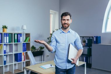 Ofiste başarılı bir iş adamının portresi, işte bir adam, kameraya bakıyor ve el ele tutuşup gülümsüyor.