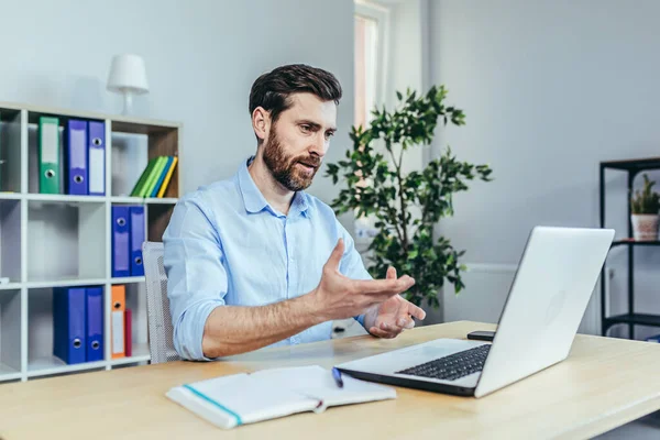 Başarılı iş kadını dizüstü bilgisayara bakar ve ofisteki adamla konuşur.