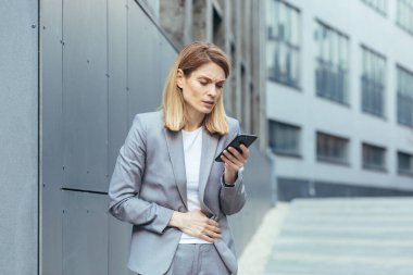 Ofisin dışındaki kadın şiddetli karın ağrısı çekiyor. Doktoru aramaya çalışıyor.