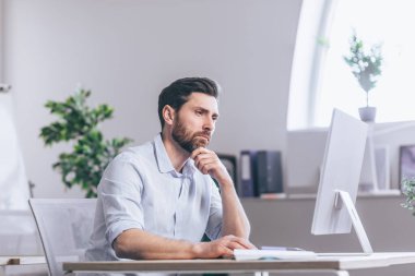 Güvenilir iş adamı, ofiste monitör ekranının önünde oturmuş veri analizi analizi yapan borsacı. Eski ticaret ajansı çalışanı kâr artışını inceliyor