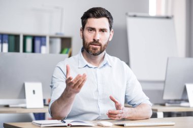 İş adamı webcam 'e bakıyor, video görüşmesinde konuşuyor, el kol hareketi yapıyor, iş arkadaşlarıyla online konferans yapıyor.