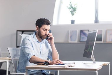 Bilgisayarın ofisinde çalışan konsantre ve düşünceli bir işadamı, evrak komisyoncusu, monitöre bakan bir adam.