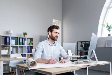 Deneyimli mimar ev boyası projesi üzerinde çalışıyor. Ofisteki adam.