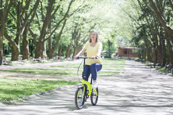 Ενεργός Συνταξιούχος Γυναίκα Οδηγεί Ένα Ποδήλατο Ένα Καλοκαιρινό Πάρκο Ένας — Φωτογραφία Αρχείου