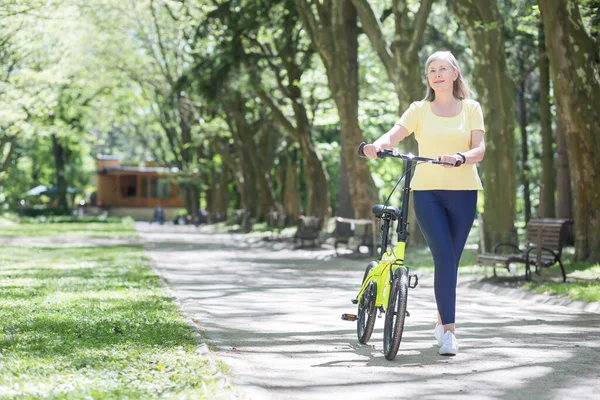 Συνταξιούχος Γυναίκα Ξεκουράζεται Στο Πάρκο Γκριζομάλλη Περσίδα Περπατά Ένα Ποδήλατο — Φωτογραφία Αρχείου