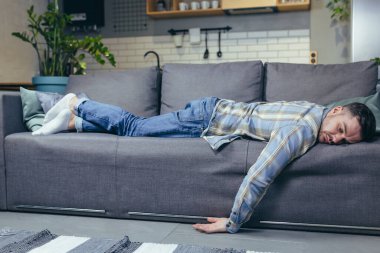 Depresyondaki adam işten sonra evde kanepede uyumaktan yoruldu.