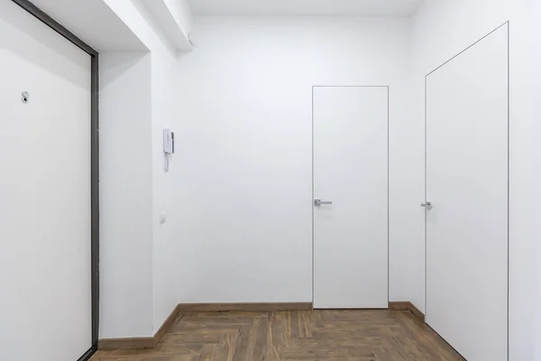 Corridor in with white walls and doors in the apartment