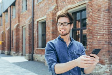 Gözlüklü genç yakışıklı başka bir ülkeye seyahat ediyor. Şehirde dolaşıyor ve bir cep telefonundan arkadaşlarına ve ailesine yapılan bir video araması ile arıyor. Elini sallıyor, selamlıyor, izlenimlerini paylaşıyor.