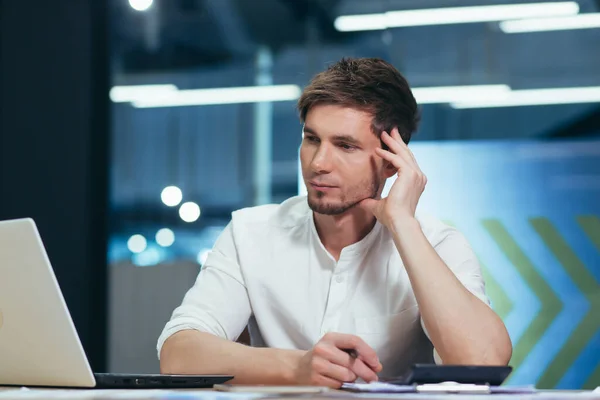 Young man thinking in office, businessman working with laptop on business plan and startup development strategy