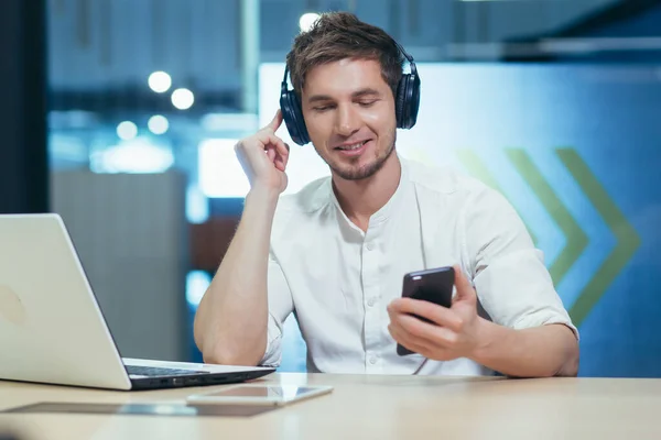Young Businessman Works Office Laptop Listens Music Big Headphones Uses — Stock Photo, Image
