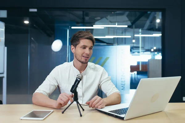 Business coach records online performance course, man works in office, uses professional microphone to record podcasts