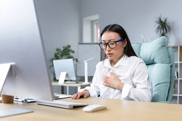 Young beautiful asian female office worker tired and sick having severe chest pain and breathing problems panic attack business woman.