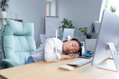 Kadın ofis çalışanı yorgun Asyalı masa başında uyuyor, aşırı yorgun gündüzleri uyuyor..