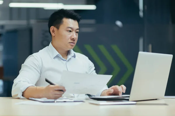 Portrait Young Serious Focused Asian Businessman Working Documents Laptop Sitting — Stockfoto