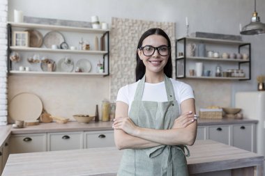 Gecelik giymiş güzel ev kadınının portresi. Kollarını kavuşturmuş, gülümseyen ve kameraya bakan kadın.