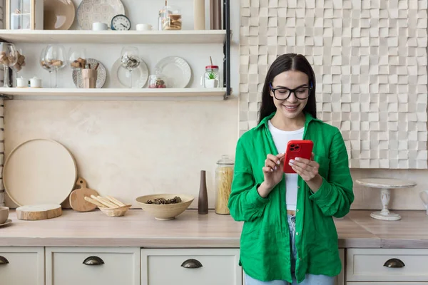 Beautiful Woman Glasses Green Shirt Using Red Mobile Phone Home — Stock Photo, Image