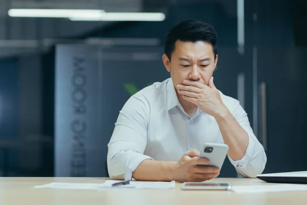 Confused Asian Guy Holding Smart Phone Feels Concerned Thinking Received — Stockfoto