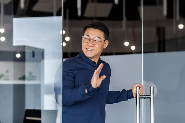 Man Walks Meeting Room Smiles Greets Asian Boss Glasses Shirt — Stock Photo, Image