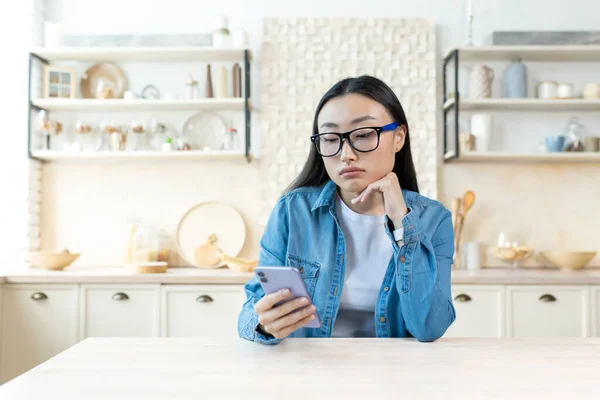 Sad Woman Home Sitting Kitchen Reading News Phone Depressed Asian — Stock Photo, Image
