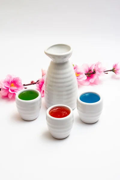 Flasche und Geschirr für Sake dekoriert witj sakura und farbigen aqua — Stockfoto