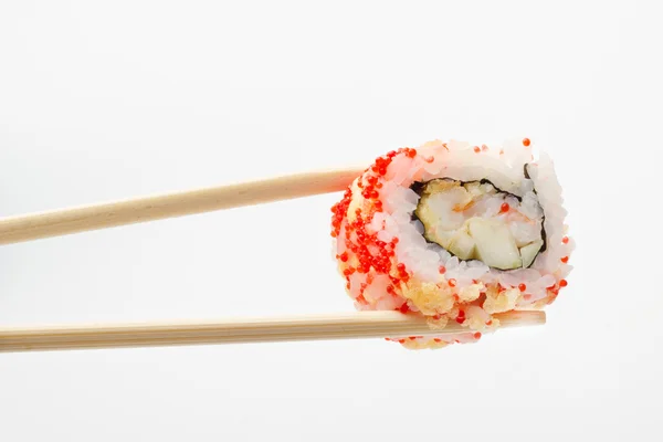 Geïsoleerde sushi roll in eetstokjes — Stockfoto