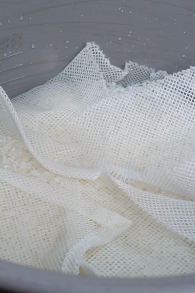 Arroz em caixa de plástico isolado sobre fundo branco — Fotografia de Stock