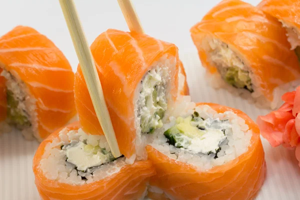 Filadélfia rolo de sushi com gengibre e wasabi na placa branca — Fotografia de Stock