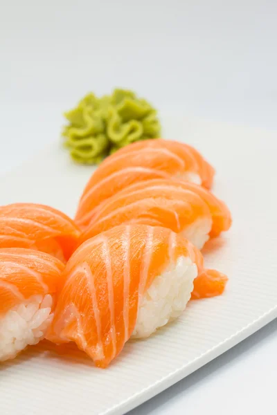 Salmone sushi nigiri su piatto bianco e sfondo — Foto Stock