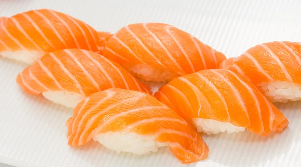 Salmón sushi nigiri sobre plato blanco y fondo —  Fotos de Stock